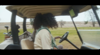 a woman driving a golf cart with a driver