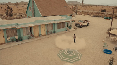 a person standing in the middle of a road with an umbrella