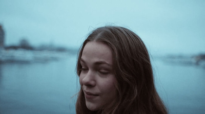 a woman standing in front of a body of water