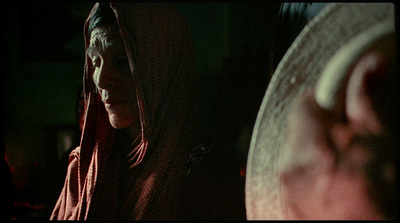 a woman in a red hoodie standing next to a drum