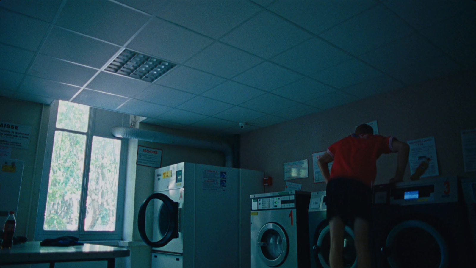 a man standing in a room next to a washer and dryer