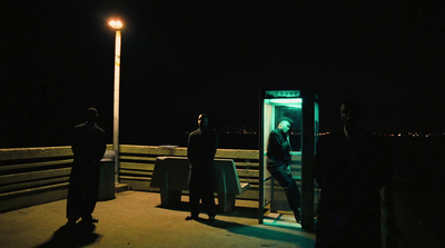 a group of people standing on a pier at night