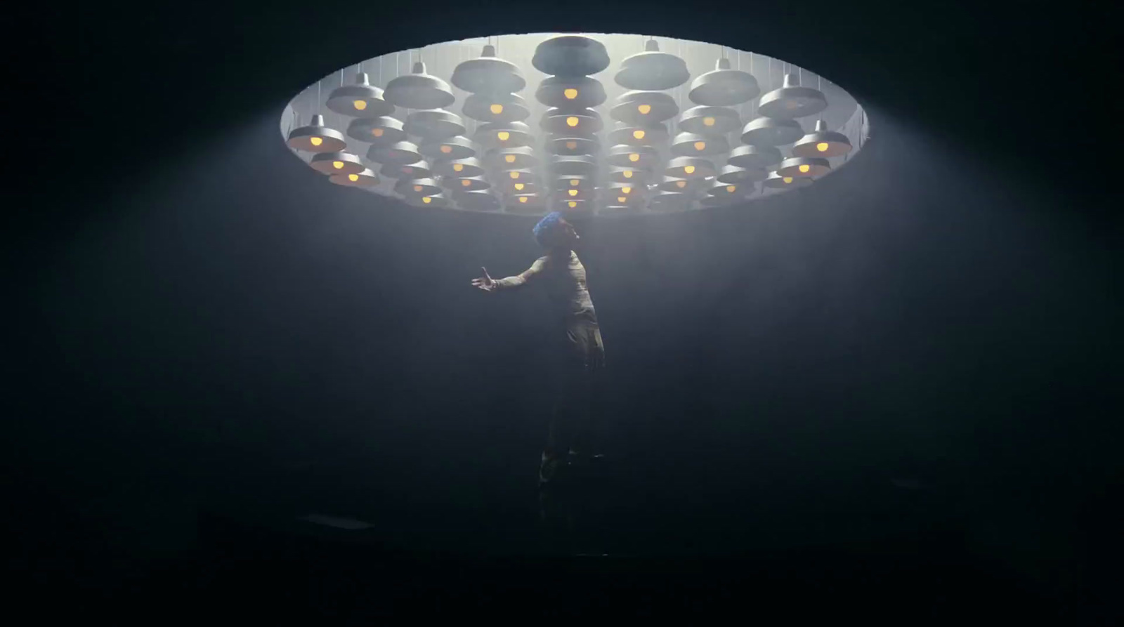 a person standing under a light in the dark