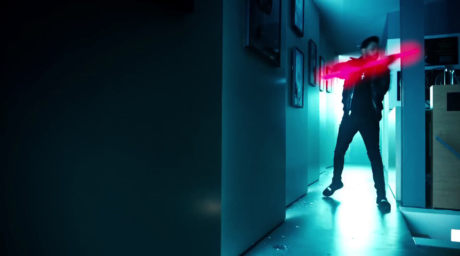 a man standing in a hallway holding a red object