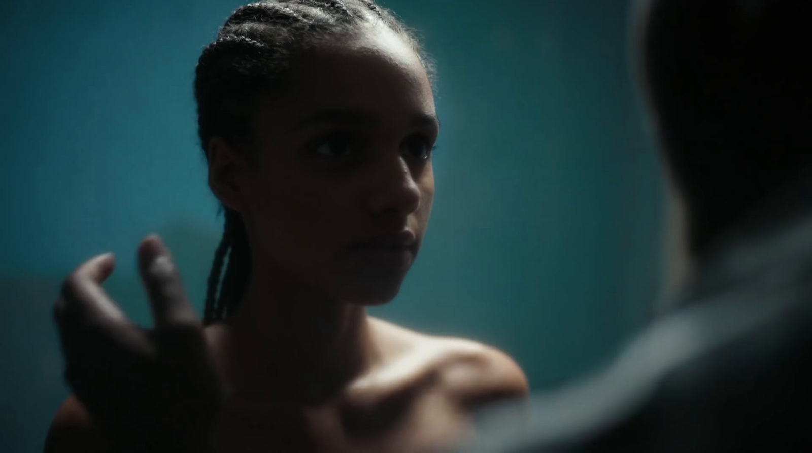 a woman with braids is looking in the mirror