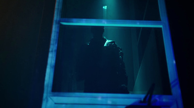 a man standing in front of a mirror in a dark room