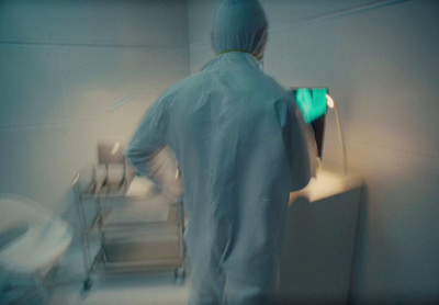 a person in a white lab coat standing next to a toilet