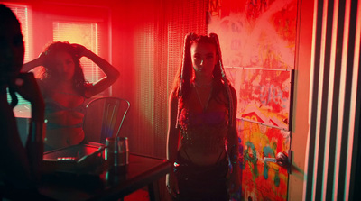 two women standing in a room with red light