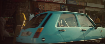 a small blue car parked in front of a store