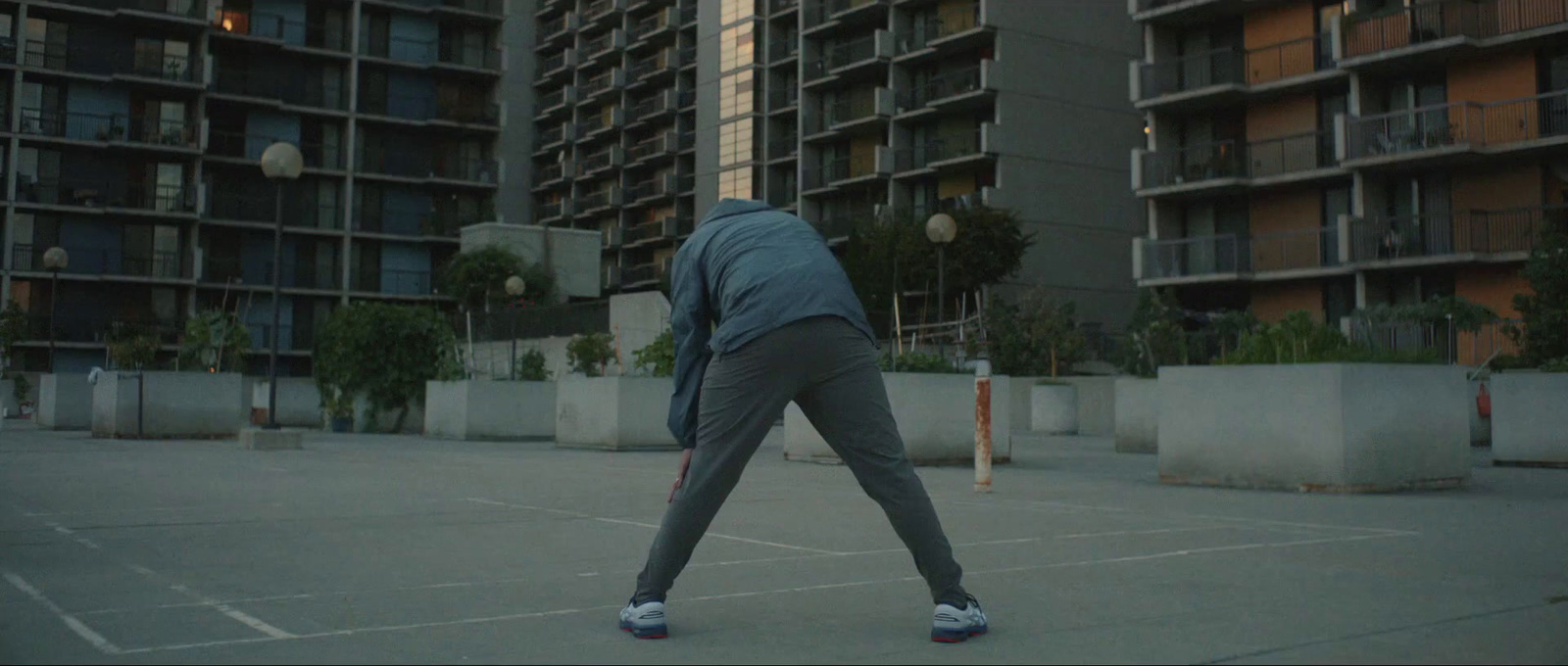 a person in a parking lot with a tennis racket