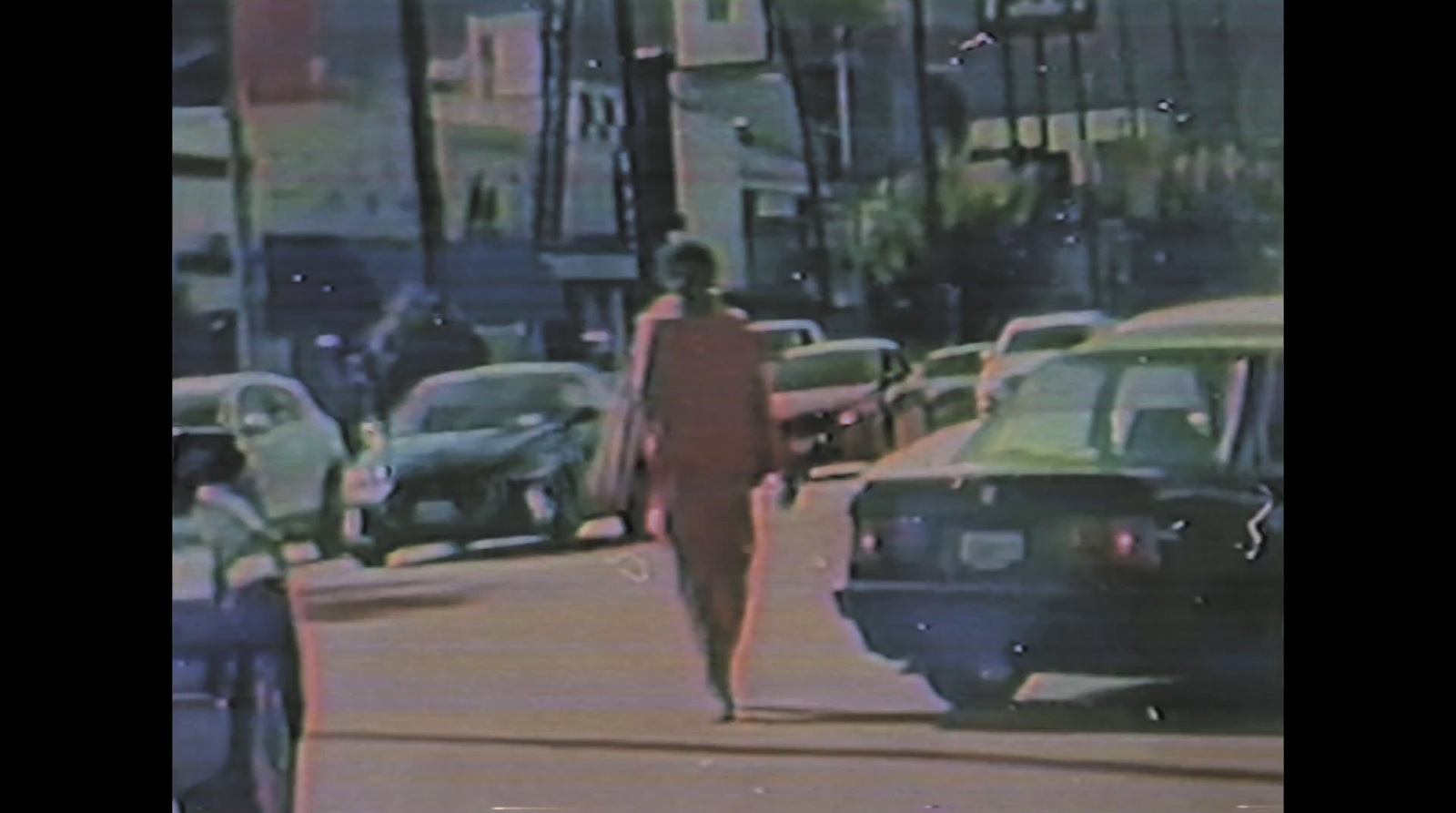 a woman in a red dress is walking down the street