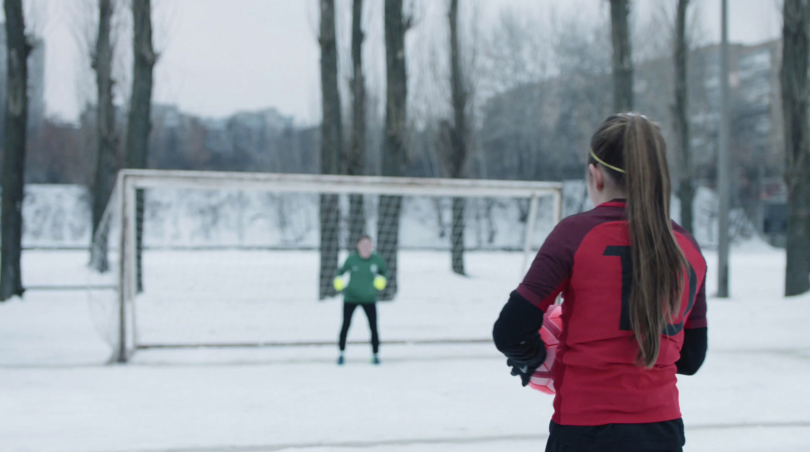 a woman standing in front of a soccer goal