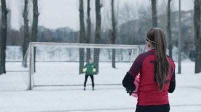 a woman standing in front of a soccer goal