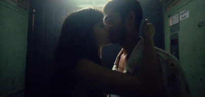 a man and a woman kissing in a dark room