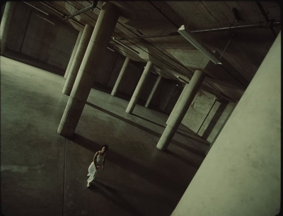 a woman standing in an empty parking garage