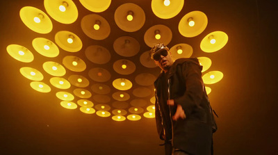 a man standing in front of a light filled ceiling