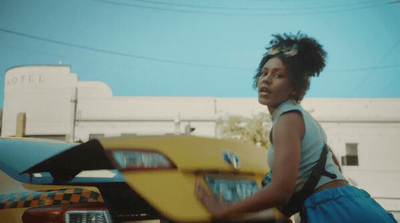 a woman standing next to a yellow car