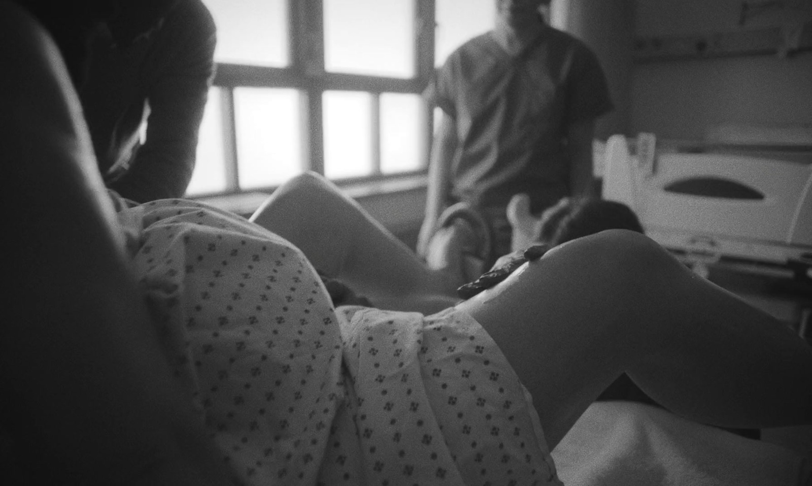 a man standing next to a woman in a hospital bed