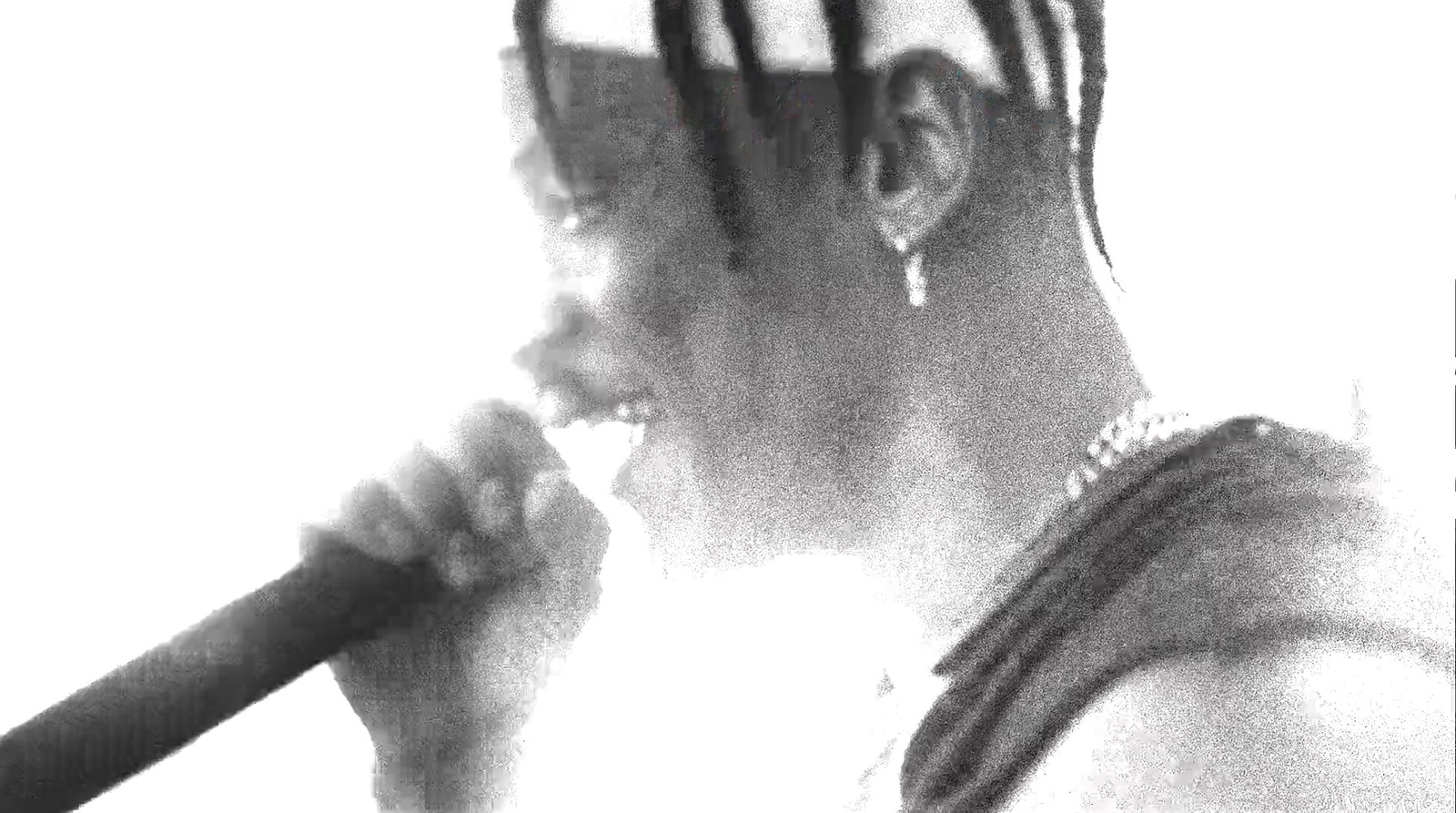 a black and white photo of a man with dreadlocks