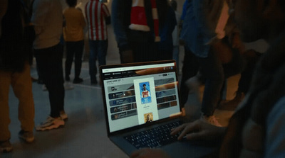 a group of people standing around a laptop computer