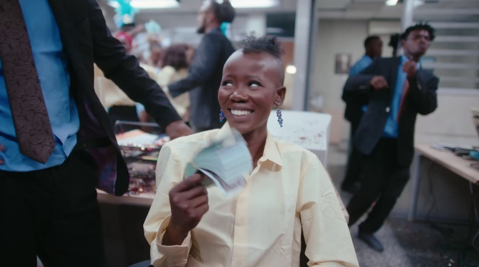 a woman is smiling and holding a piece of paper