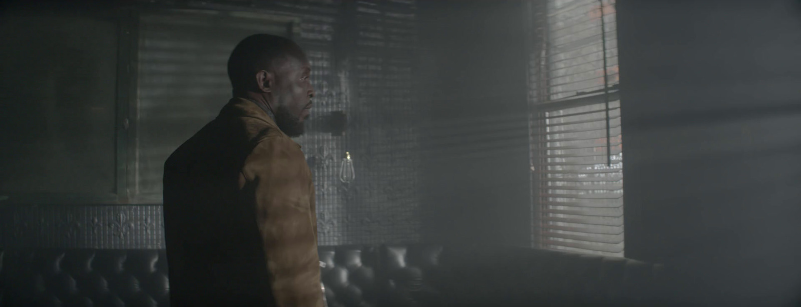 a man standing in front of a window in a dark room