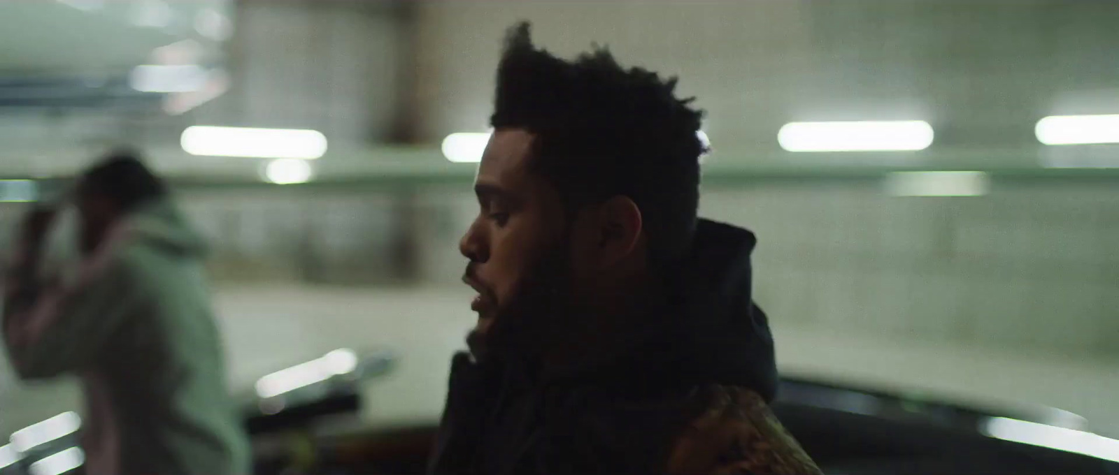 a man standing in a parking garage next to another man