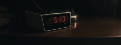 a digital clock sitting on top of a wooden table