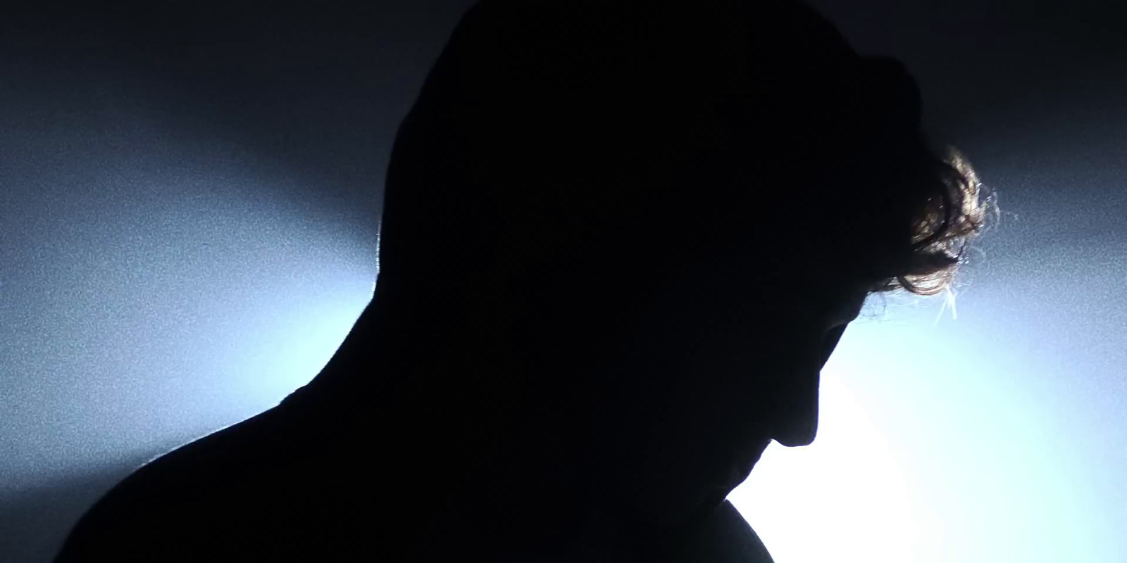 a silhouette of a man in a dark room