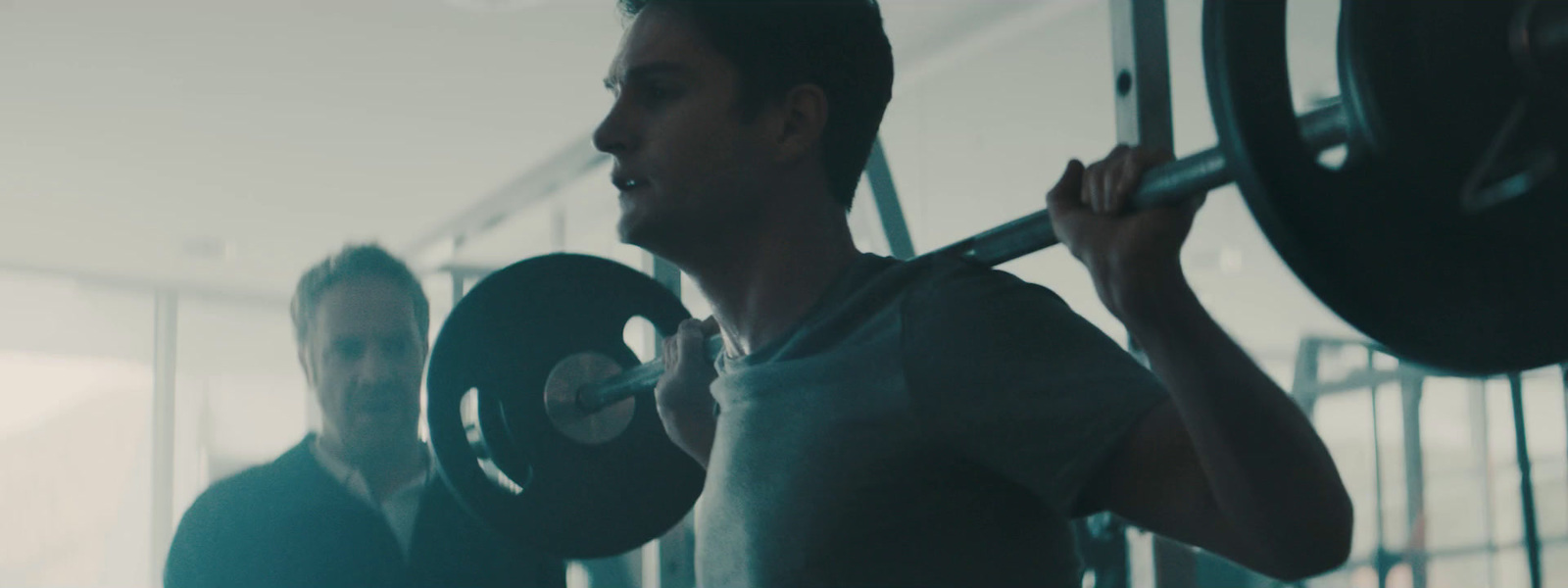 a man lifting a barbell in a gym