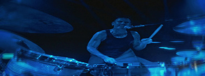 a man is playing drums on stage at a concert