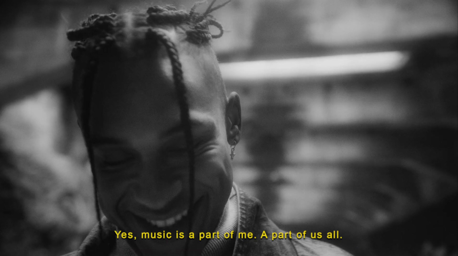 a man with dreadlocks smiles at the camera