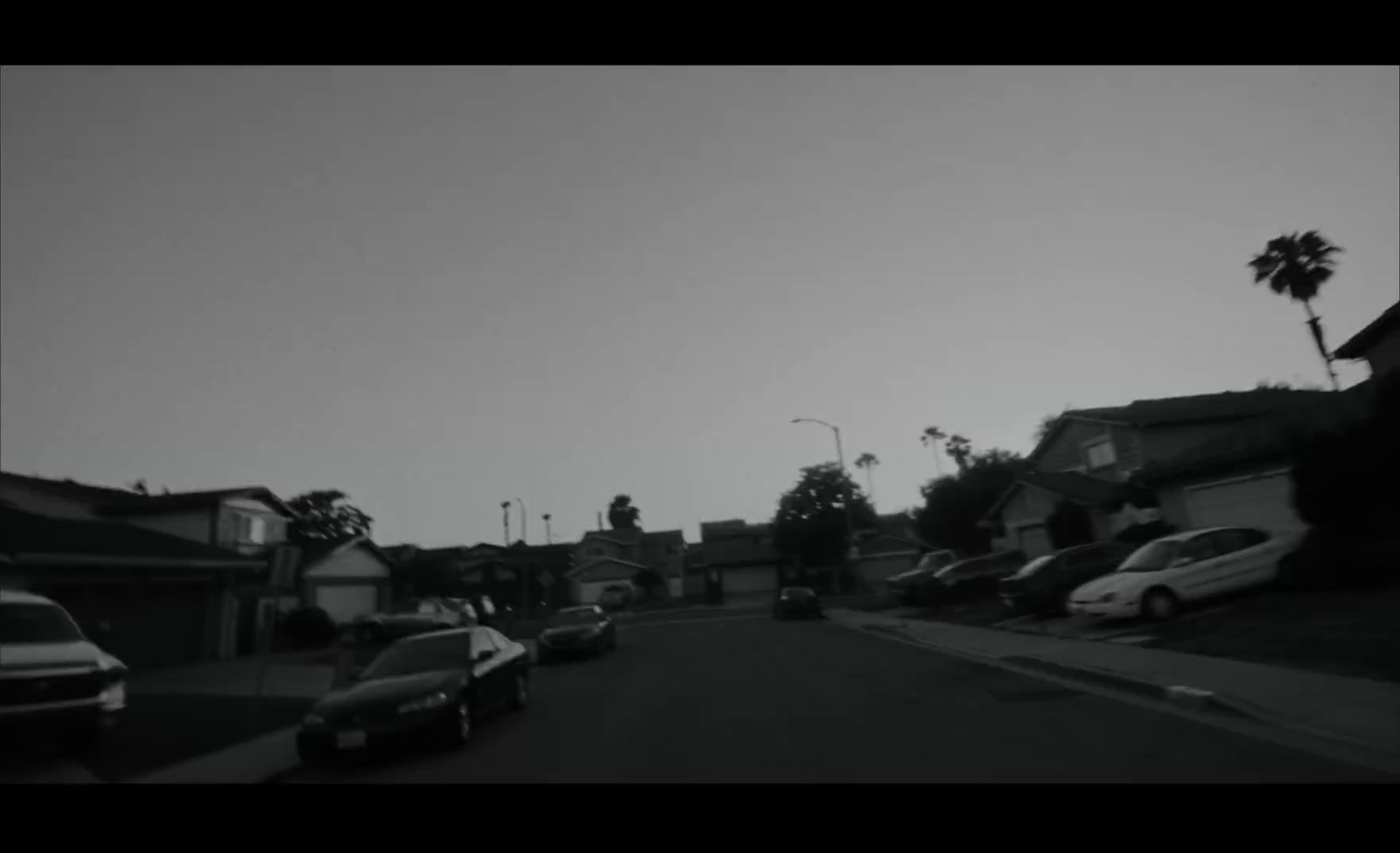 a black and white photo of cars parked on a street