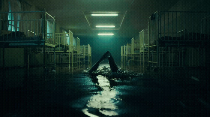 a dark hallway with a person floating in the water