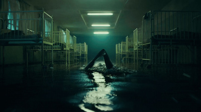 a dark hallway with a person floating in the water