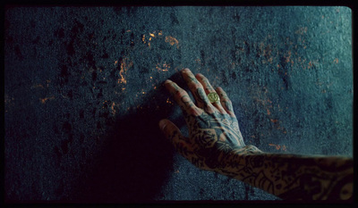 a person's hand with tattoos and a ring on it