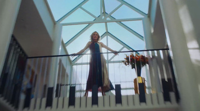 a woman in a long dress standing on a balcony