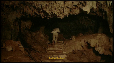 a man standing on steps in a cave