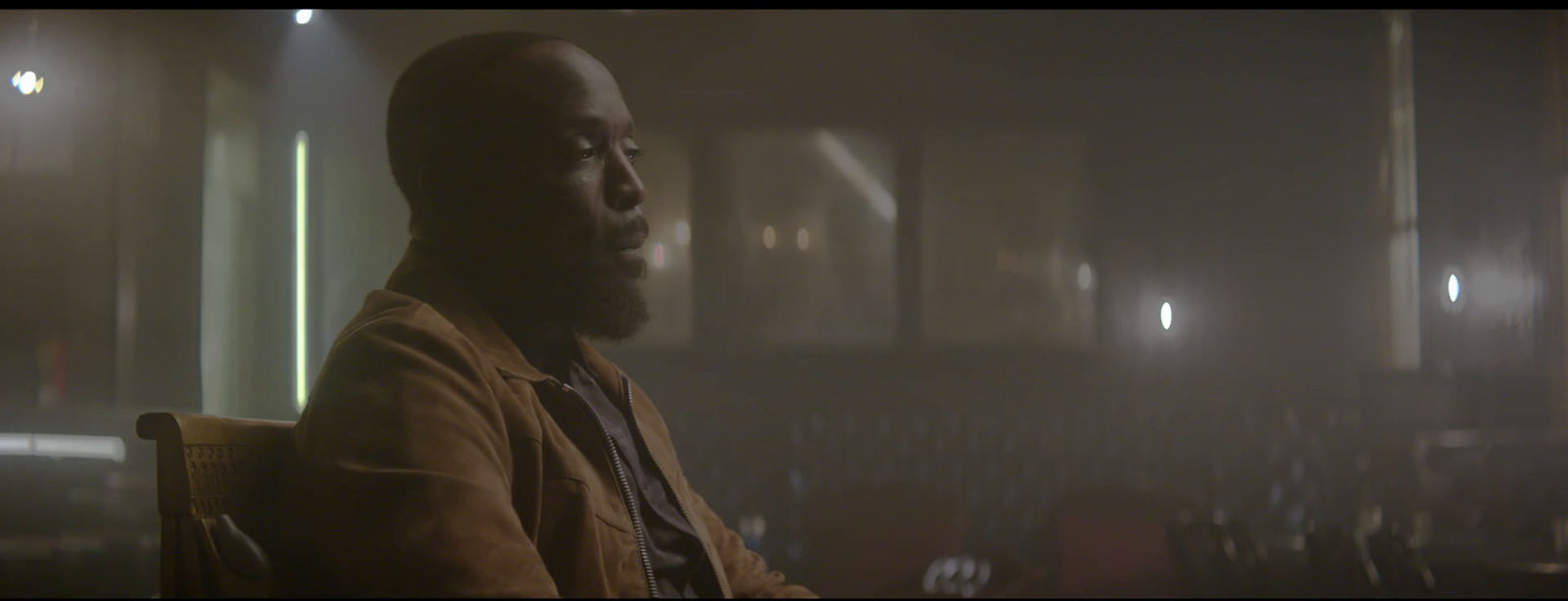 a man sitting in a chair in a dark room