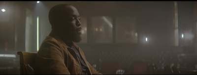 a man sitting in a chair in a dark room