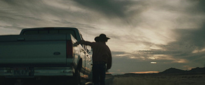 a man standing next to a truck in the desert