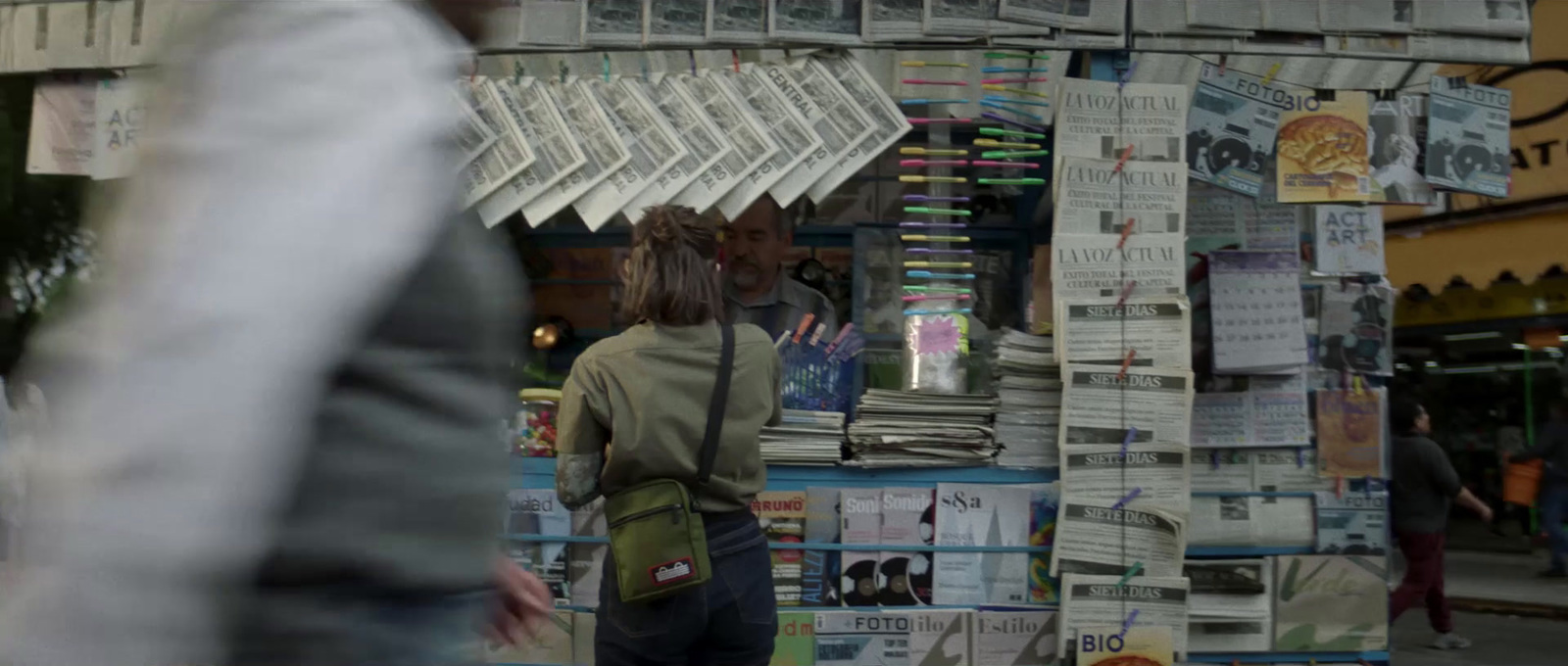 a man standing in front of a newspaper stand