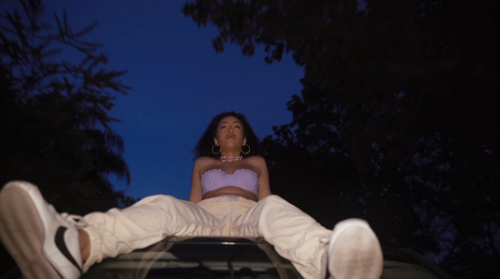 a woman sitting on the hood of a car