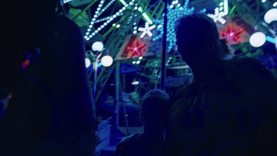 a group of people standing in front of a ferris wheel