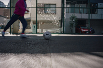 a person in a pink jacket kicking a soccer ball