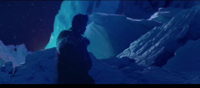 a man standing in the snow in front of ice formations