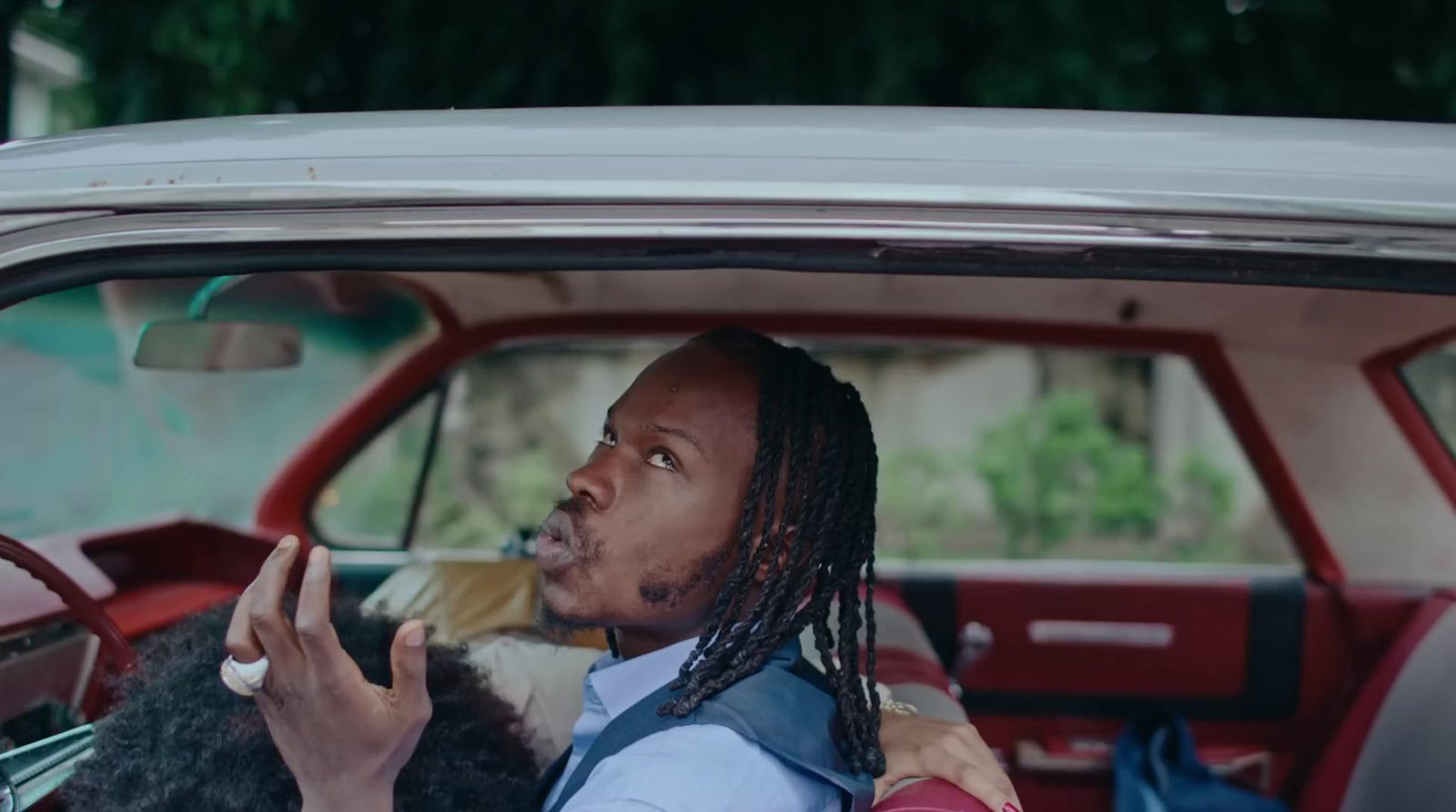 a man driving a car with a dog in his lap