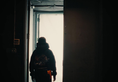 a person standing in a doorway with a backpack