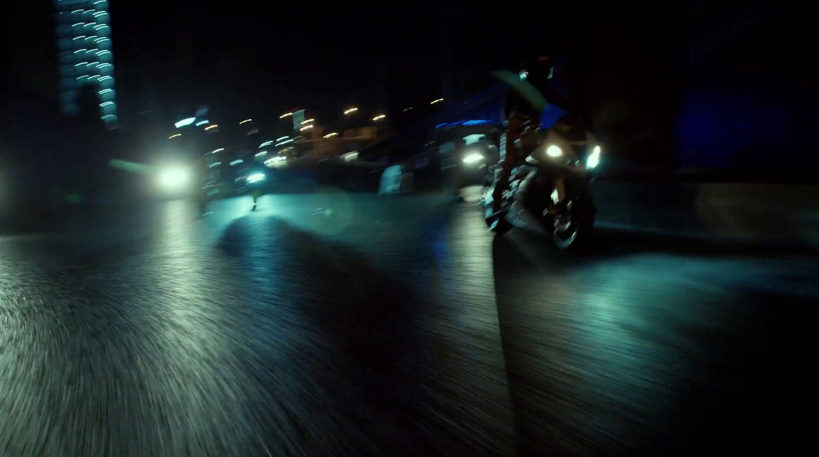 a man riding a motorcycle down a street at night