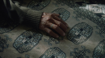 an elderly woman's hands resting on a rug